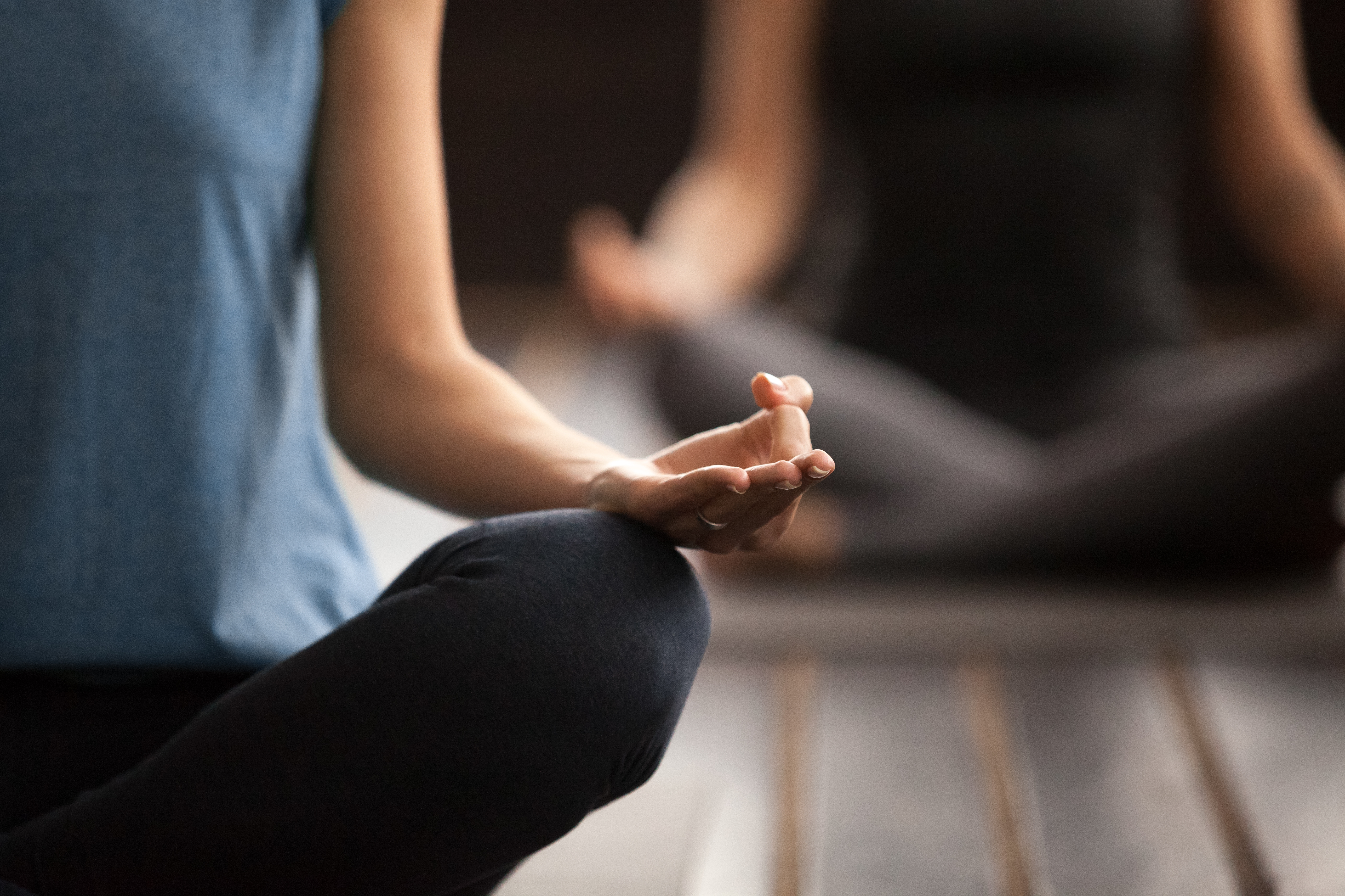 Hand mudra gesture close up, people in Sukhasana pose meditation dijon